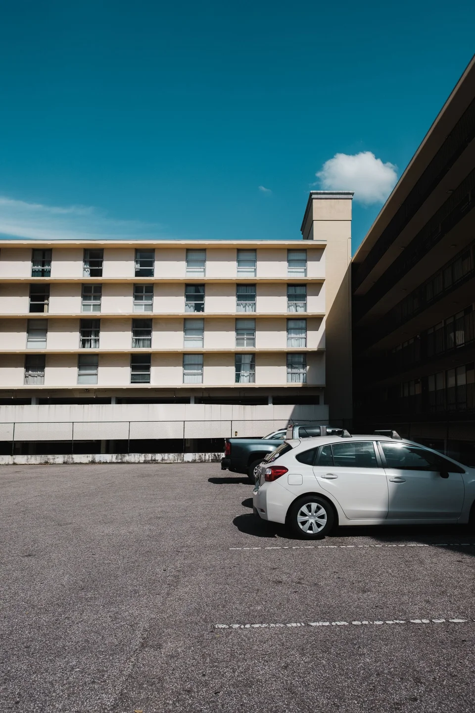 A hatchback sitting in a bright parking lot under a clear sky